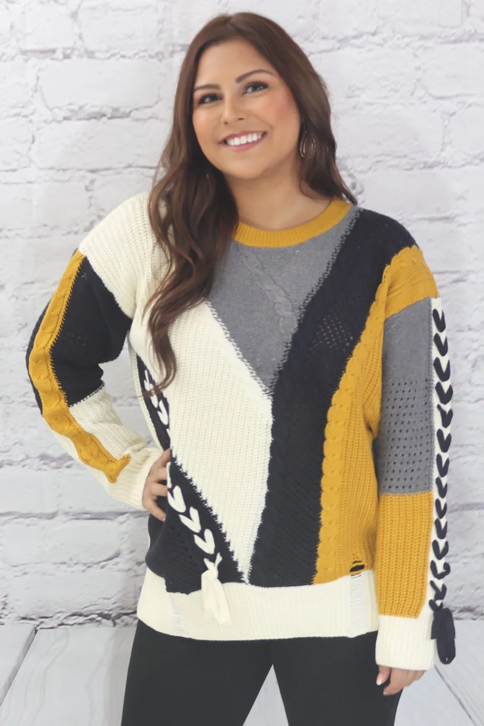 Long sleeve color block cable knit sweater with lace-up trim